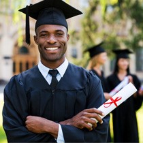 Man smiling in cap and gown
