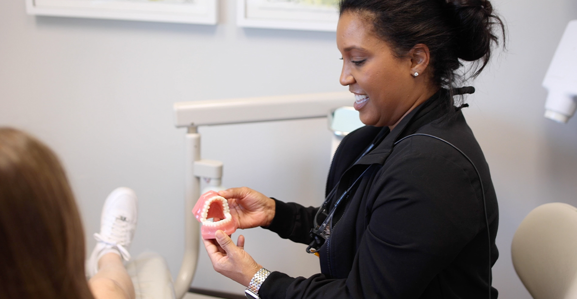 Cosmetic dentist in Atlanta holding a model of the teeth