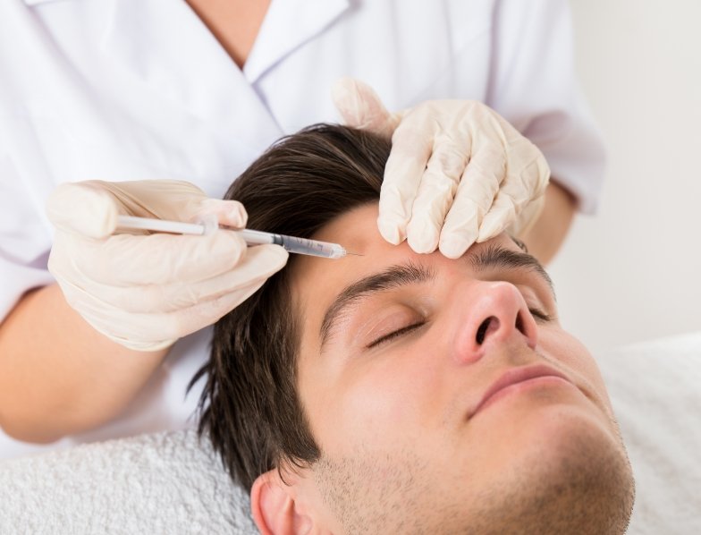 Man receiving Botox injection in his forehead