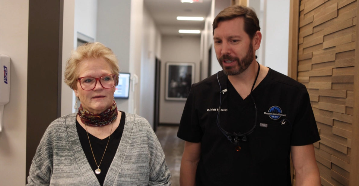 Dentist talking to a patient in hallway