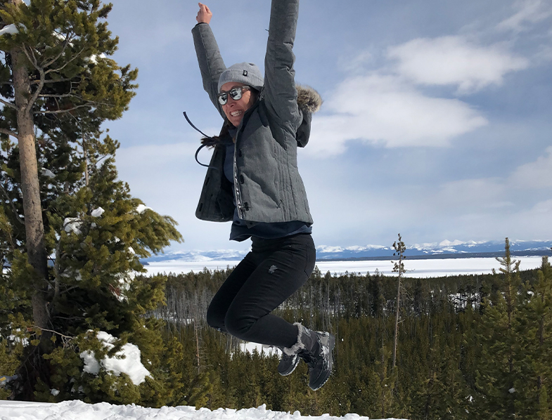 Doctor Megan jumping on a snowy mountain top