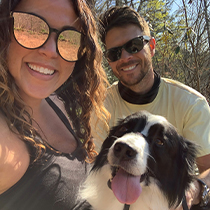 Doctor Velasco smiling with her husband and their dog