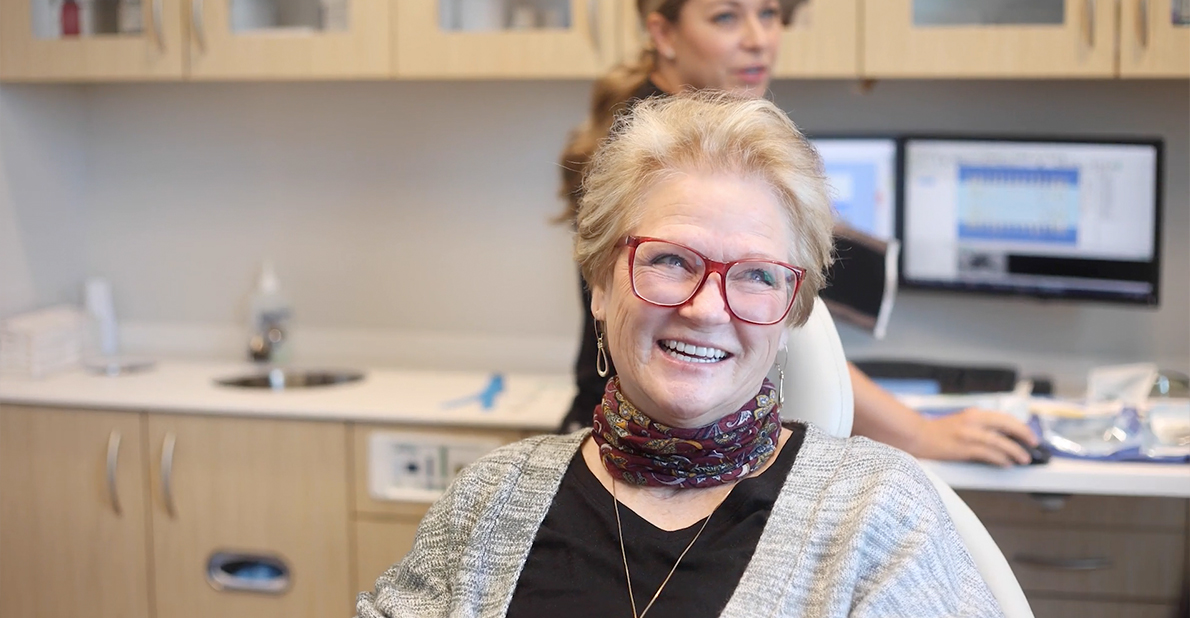 Senior woman smiling after replacing missing teeth in Atlanta