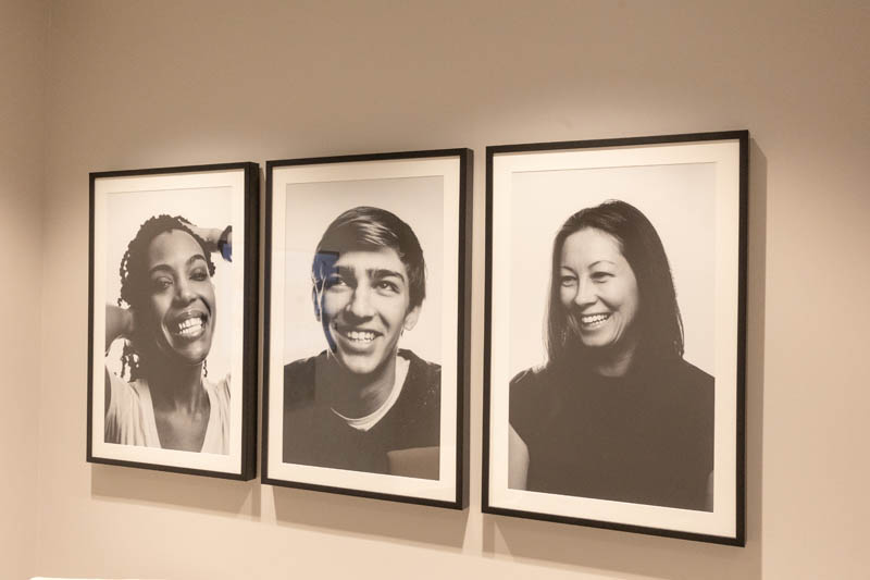 Photos of smiling people on wall