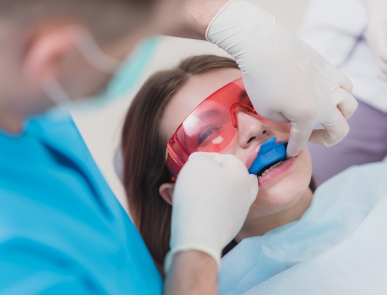 Young woman getting fluoride treatment in dental office