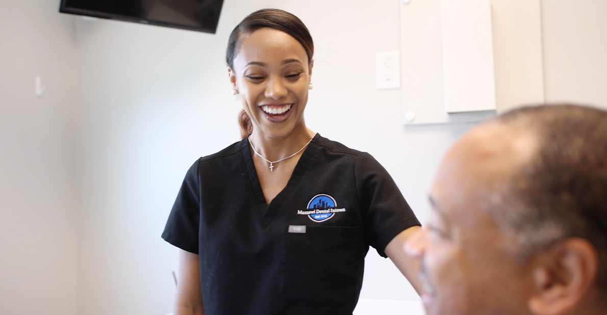 Dental team member laughing with patient