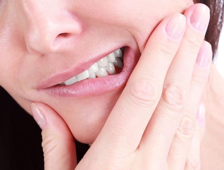 Close up of person holding their jaw in pain