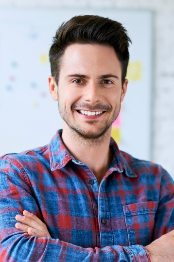 Smiling man in red and blue plaid shirt